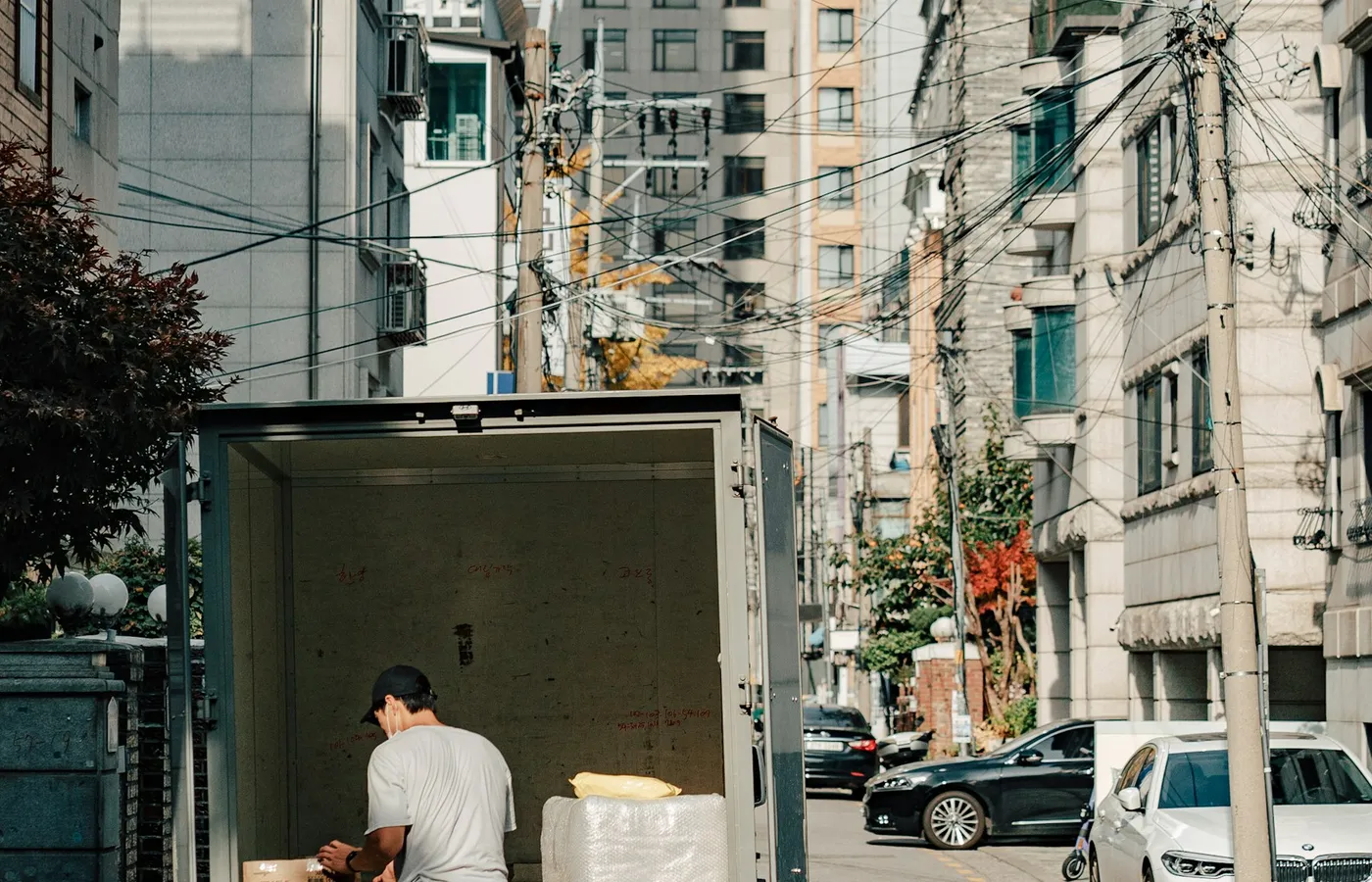 주택가 골목의 이삿짐 차량에 상자를 싣는 작업자